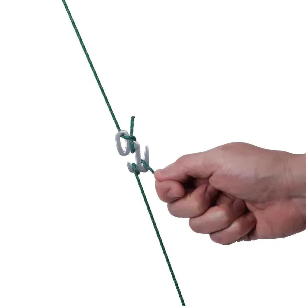 A hand adjusts the silver Nite Ize Figure 9 Rope Tightener - Small on a green rope against a white background.
