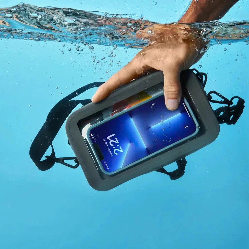 A hand holds the Nite Ize RunOff Waterproof Hip Pack in black underwater, showing the phone screen and straps.