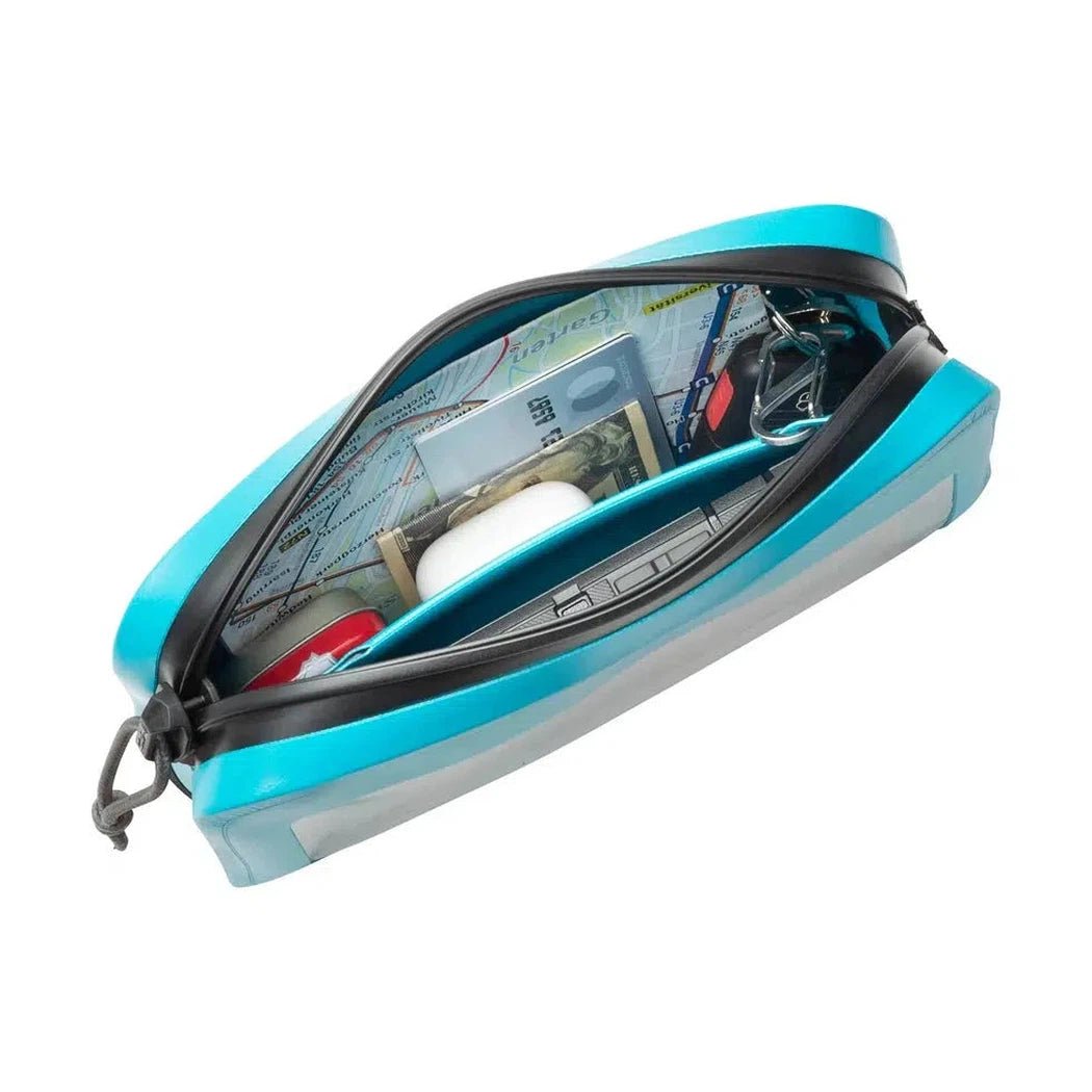 A top-down view of the Nite Ize RunOff Waterproof Hip Pack in Black, showing its waterproof zipper and contents like cash and keys inside.