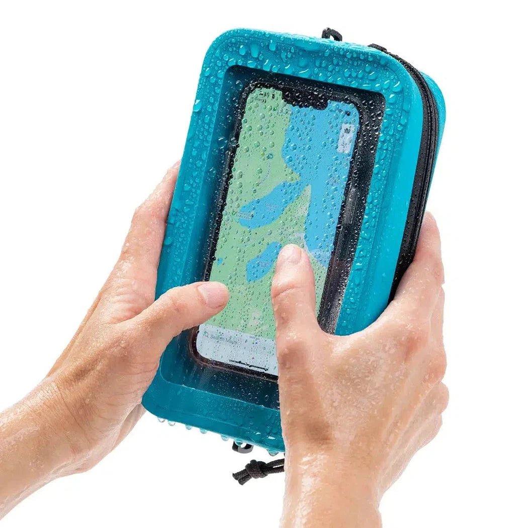 A person holding the black Nite Ize RunOff Waterproof Hip Pack with a phone inside, showing water droplets on the pack.