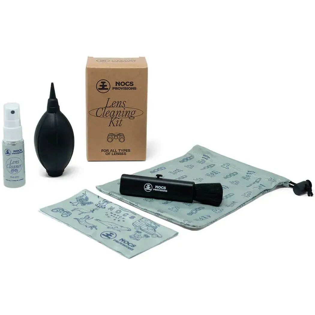 A NOCS Provisions Lens Cleaning Kit with a black blower, spray bottle, microfiber cloth, and cleaning pen displayed on a white background.