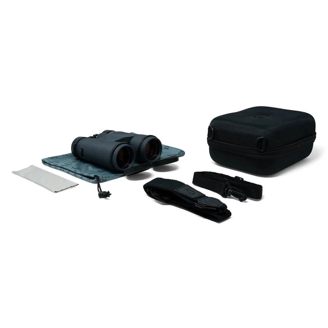 A top-down view of the Nocs Provisions Pro Issue Waterproof Binoculars in Harbor Blue with their case and accessories laid out on a white background.