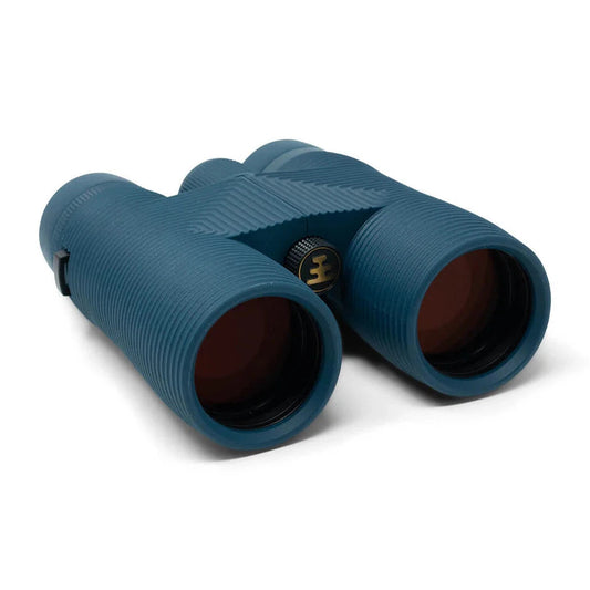 Side view of the Nocs Provisions Pro Issue Waterproof Binoculars in Harbor Blue showing the textured grips and central focus wheel against a white background.