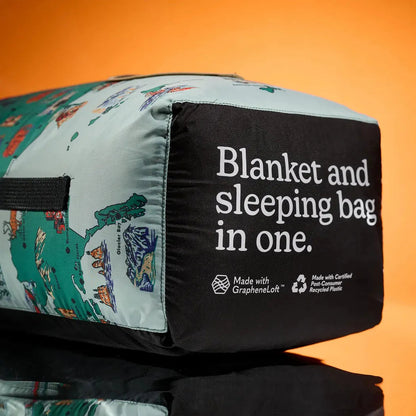 A side view of the Nomadix Graphene Puffer Blanket with a National Parks and Monuments Map design against an orange background.