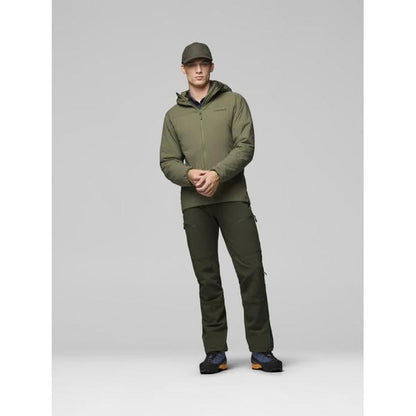 A model wearing the Norrona Men's Femund Thermo60 Zip Hood in Indigo Night stands against a light gray background.