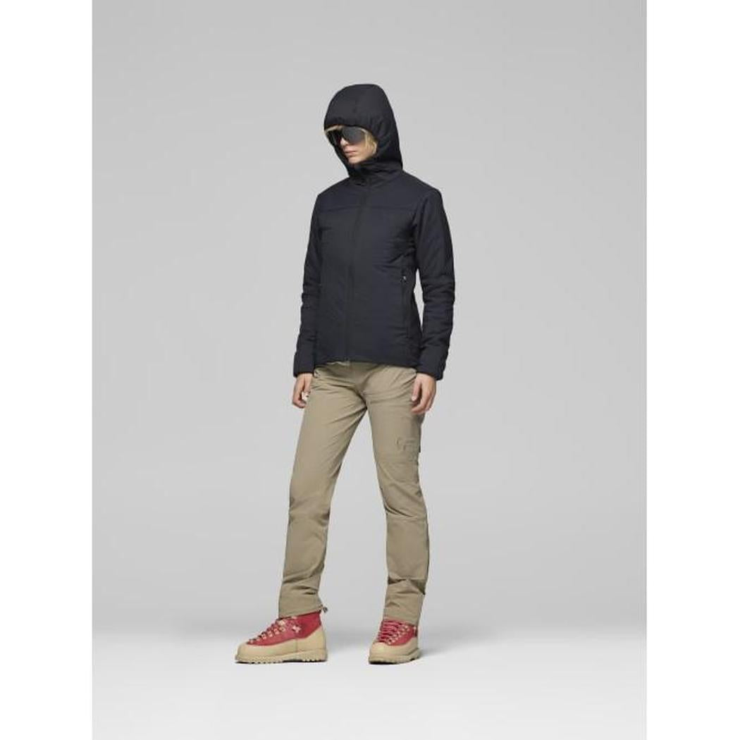 A model wearing the Norrona Women's Femund Thermo60 Zip Hood in Caviar Black stands against a light gray background.