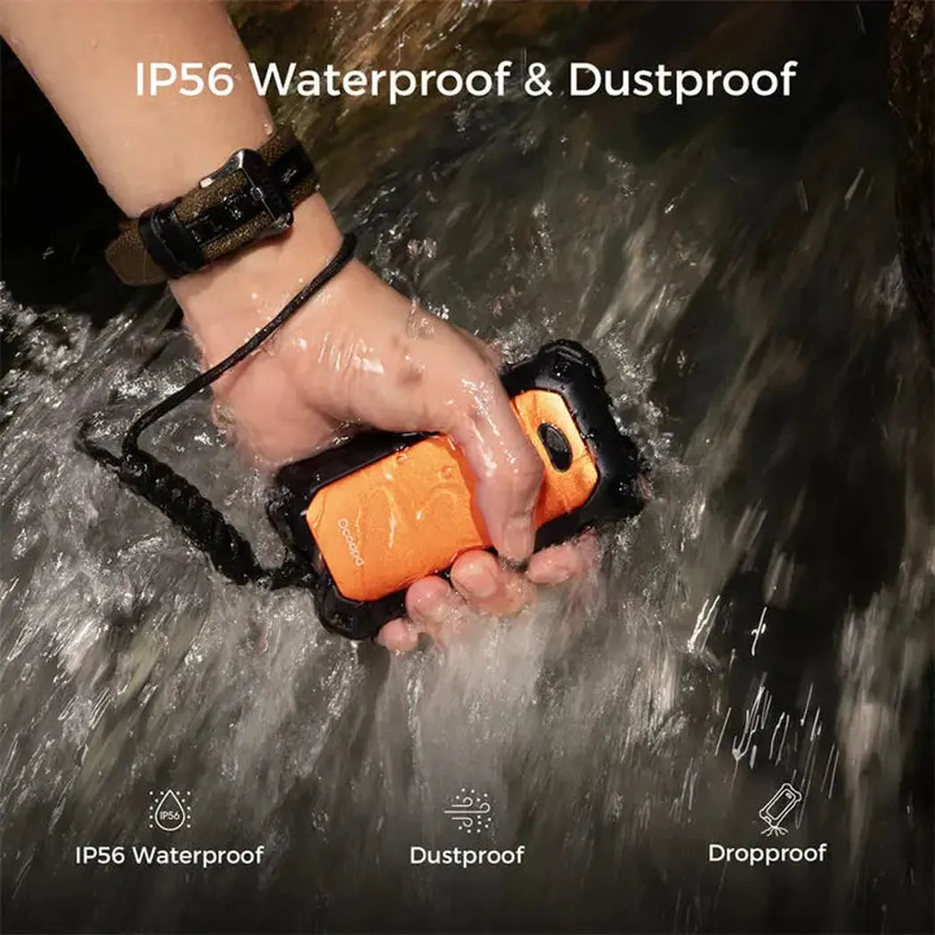 A hand holds the orange Ocoopa UT4 Extreme Ip56 Waterproof Outdoor Hand Warmers in rushing water, showing its waterproof feature.