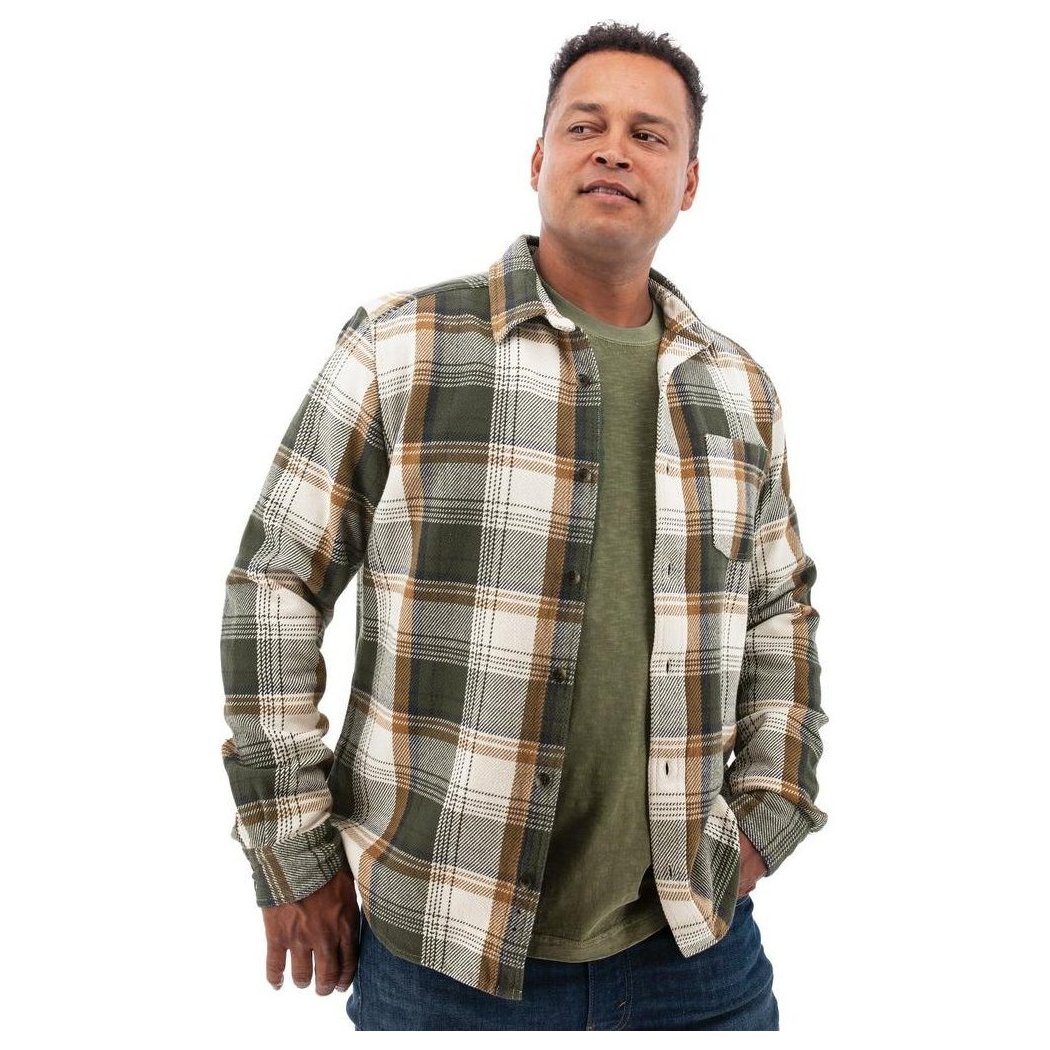 A man wearing the Old Ranch Men's Miles Shirt 25 in Thyme stands with one hand in his pocket against a white background.