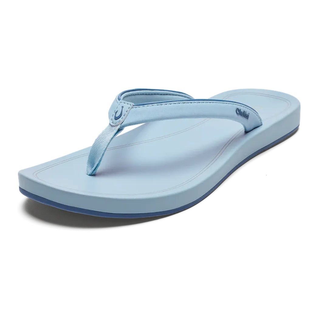 A side view of the Olukai Women's ‘Uiki in Bright Sky showing the logo on the strap against a white background.