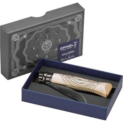 A top-down view of the Opinel No.08 Artist Limited V Cosmos Edition - Benjamin Jeanjean knife in its charcoal/gray box with a blue interior.