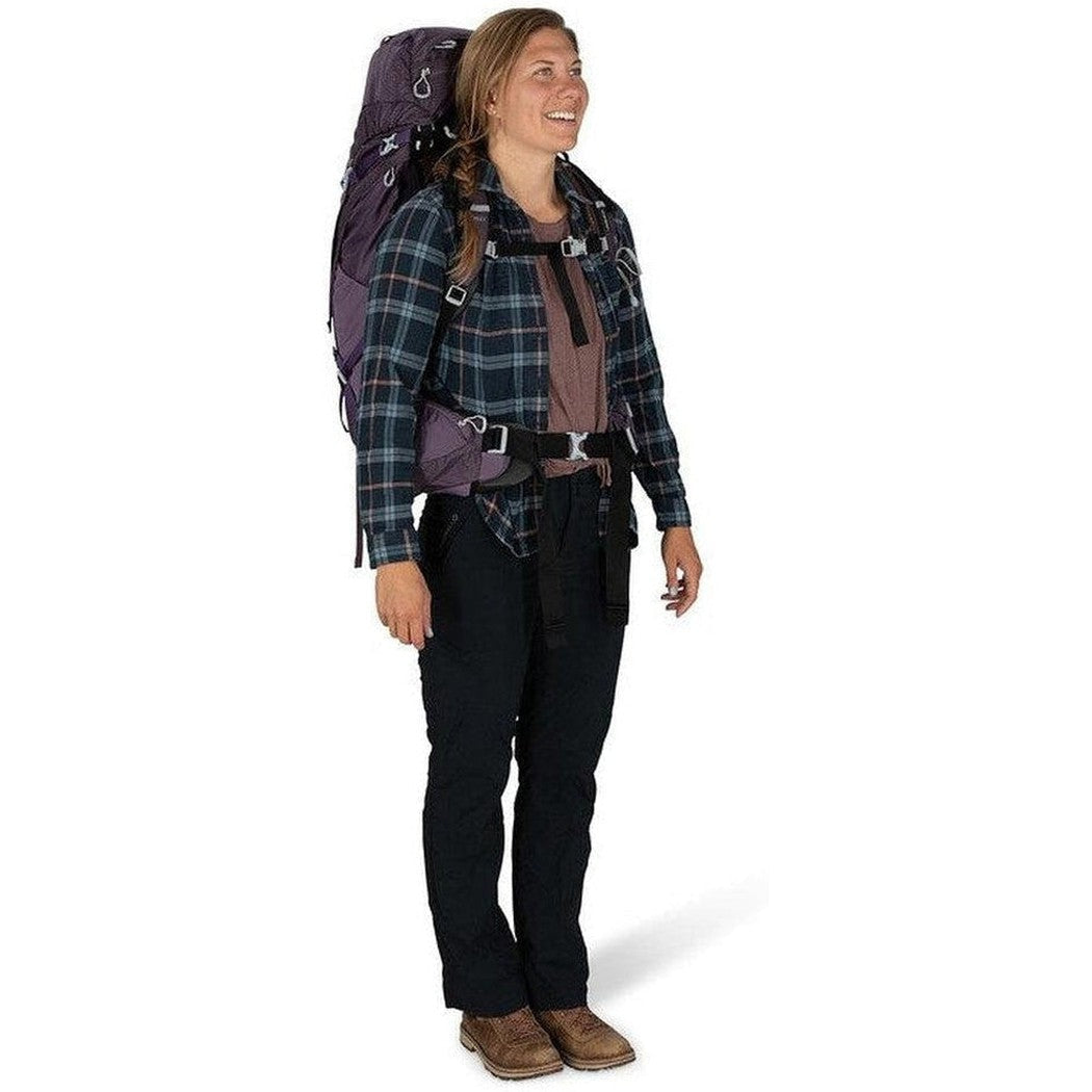 A woman wearing the Osprey Aura AG 50 backpack stands against a white background.