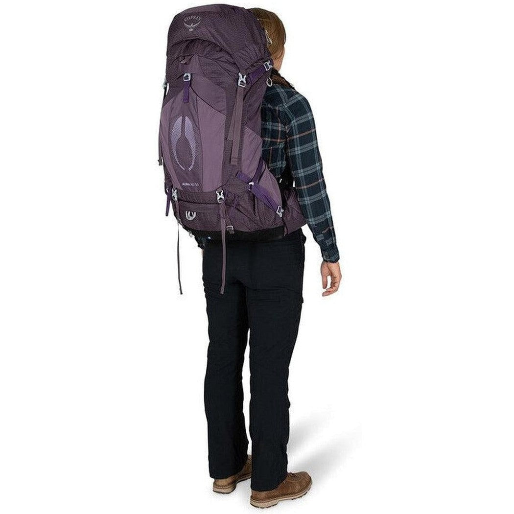 Back view of the Osprey Aura AG 50 in Berry Sorbet Red on a model wearing a plaid shirt against a white background.