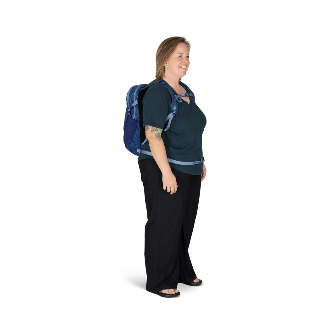 Side view of the Osprey Daylite backpack in Black on a model against a white background.