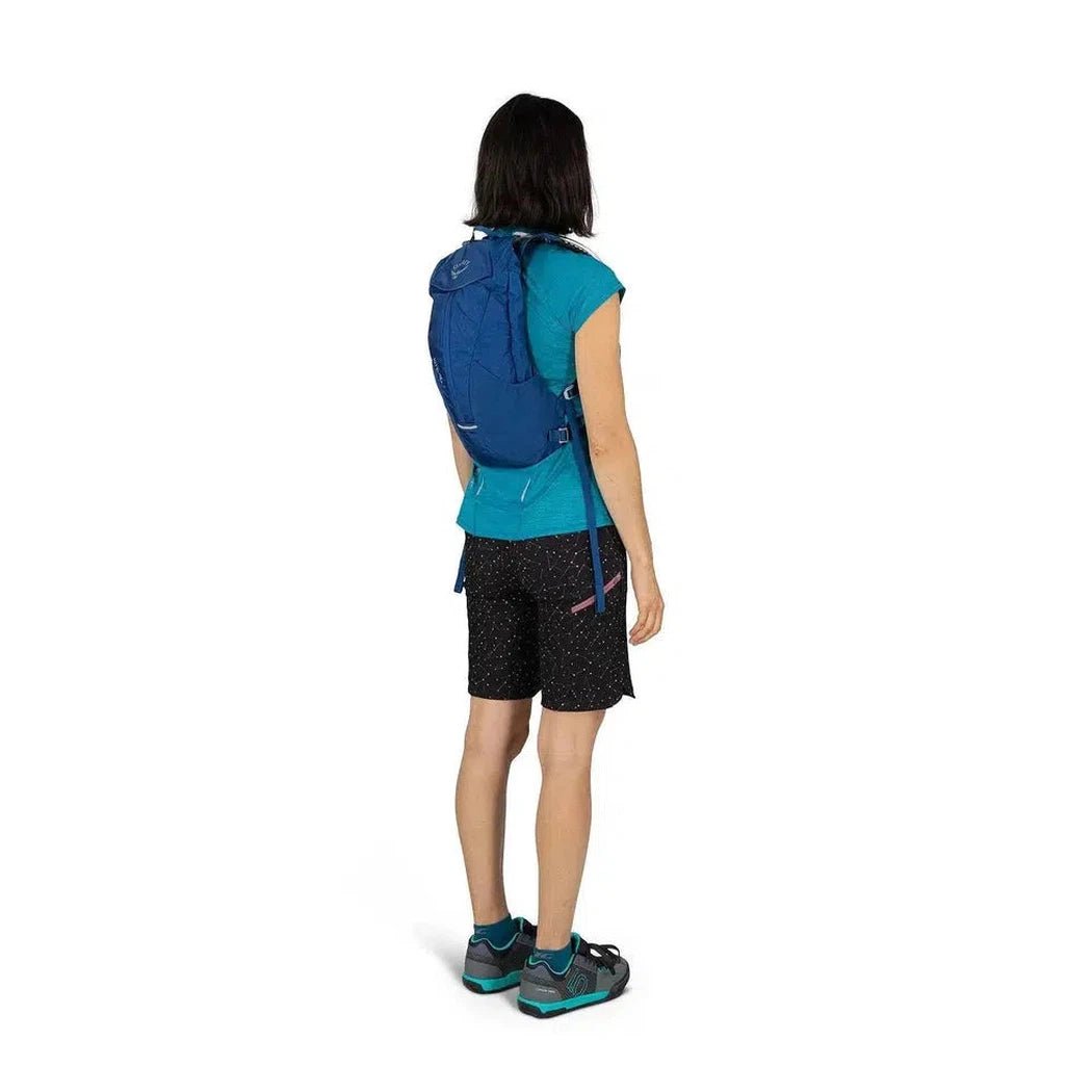 Back view of the Osprey Kitsuma 7 hydration pack in SpaceTravelGrey on a model wearing it against a white background.