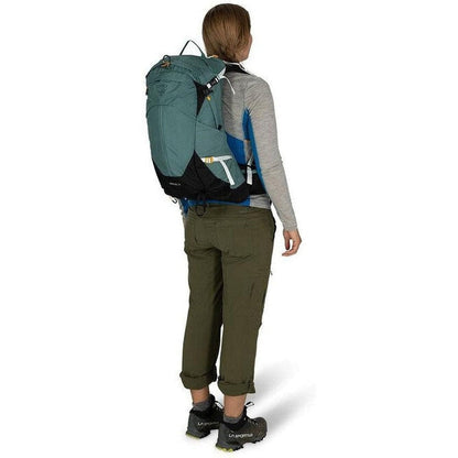 Back view of the Osprey Sirrus 24 in Medium Grey on a model wearing olive pants against a white background.