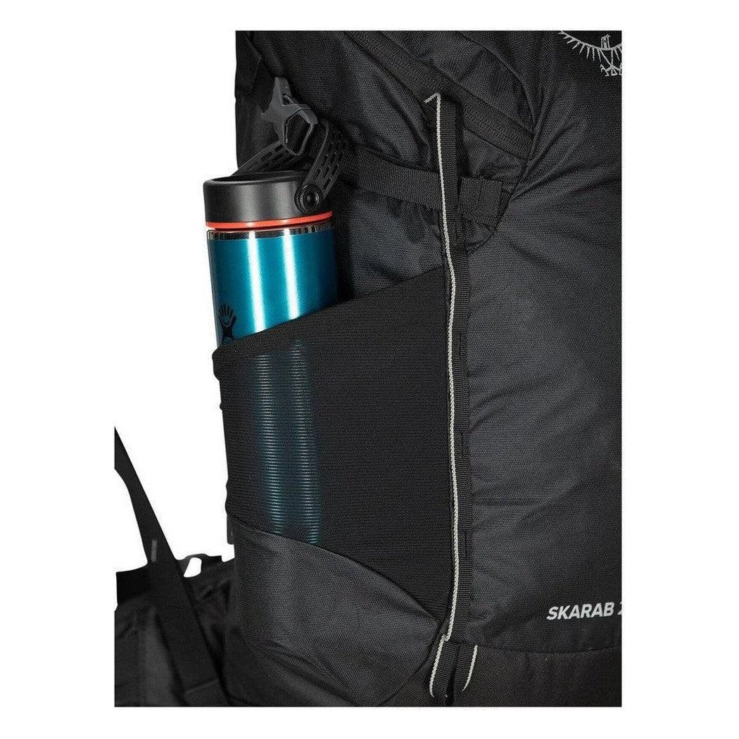Side pocket of the Osprey Skarab 22 backpack showing a blue water bottle in the mesh pocket.