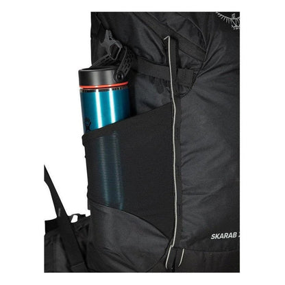 Side pocket of the Osprey Skarab 22 backpack showing a blue water bottle in the mesh pocket.