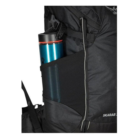 Side pocket of the Osprey Skarab 22 backpack showing a blue water bottle in the mesh pocket.