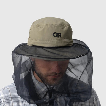 A front view of the Outdoor Research Helios Bug Hat in Ranger Green with a black mesh face net, worn by a man in a plaid shirt against a plain white background.
