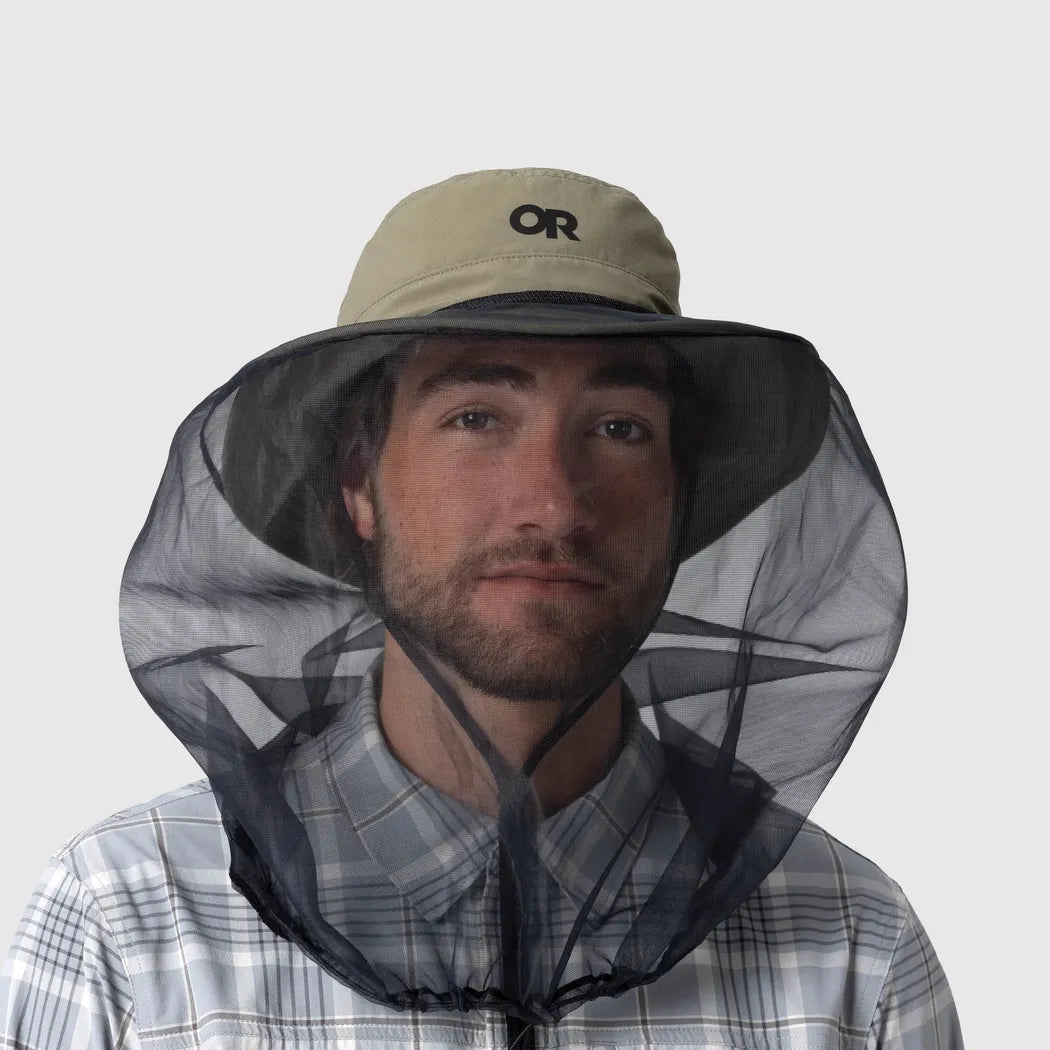 A front view of the Outdoor Research Helios Bug Hat in Ranger Green on a model wearing a plaid shirt against a plain background.