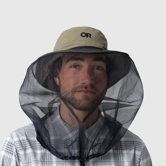 A front view of the Outdoor Research Helios Bug Hat in Ranger Green on a model wearing a plaid shirt against a plain background.