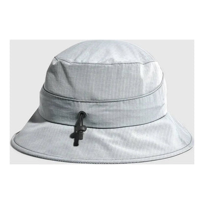 A front view of the Outdoor Research Sun Bucket Hat in Gravel with a black drawstring and a light gray background.