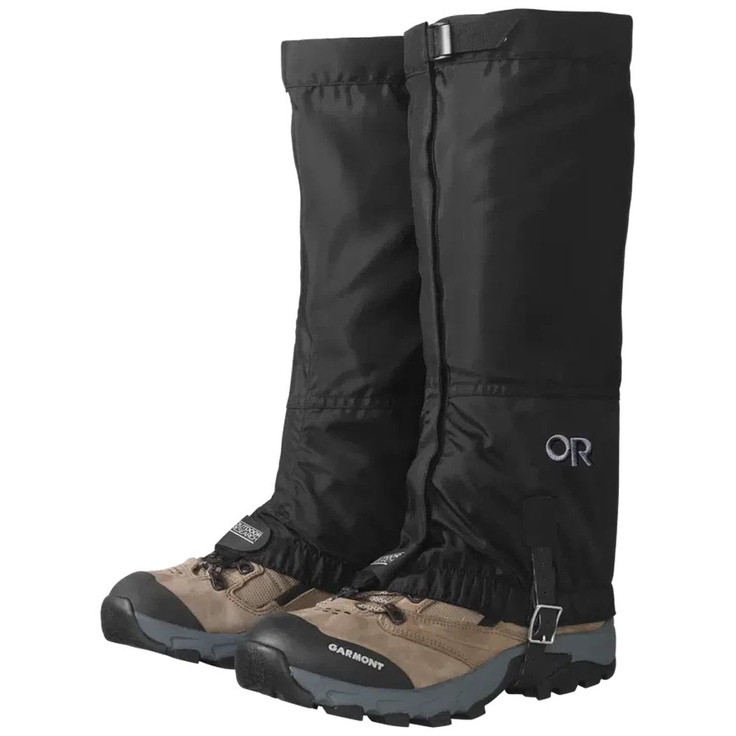 Black Outdoor Research Women's Rocky Mountain High Gaiters on tan hiking boots with buckles, shown from a front angle against a white background.