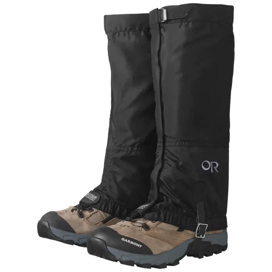 Black Outdoor Research Women's Rocky Mountain High Gaiters on tan hiking boots with buckles, shown from a front angle against a white background.