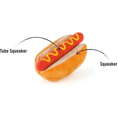 A top-down view of the P.L.A.Y American Classic Hot Diggy Dog pet toy showing the tube squeaker and bun squeaker features against a white background.
