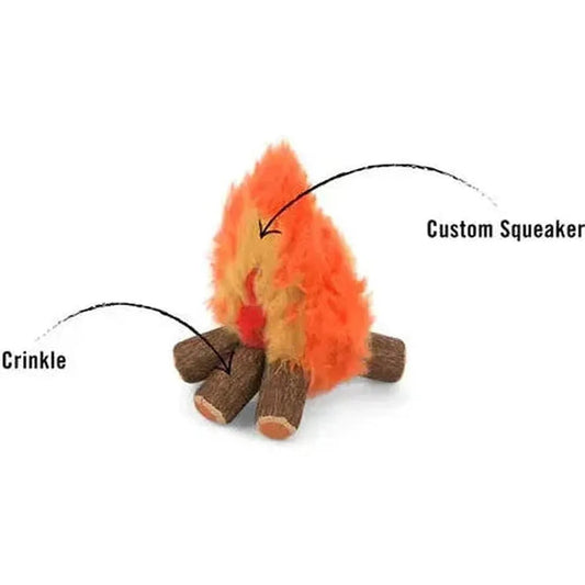 A close-up of the P.L.A.Y Camp Corbin Cozy Campfire pet toy with orange fur and brown logs, showing its crinkle and custom squeaker features.