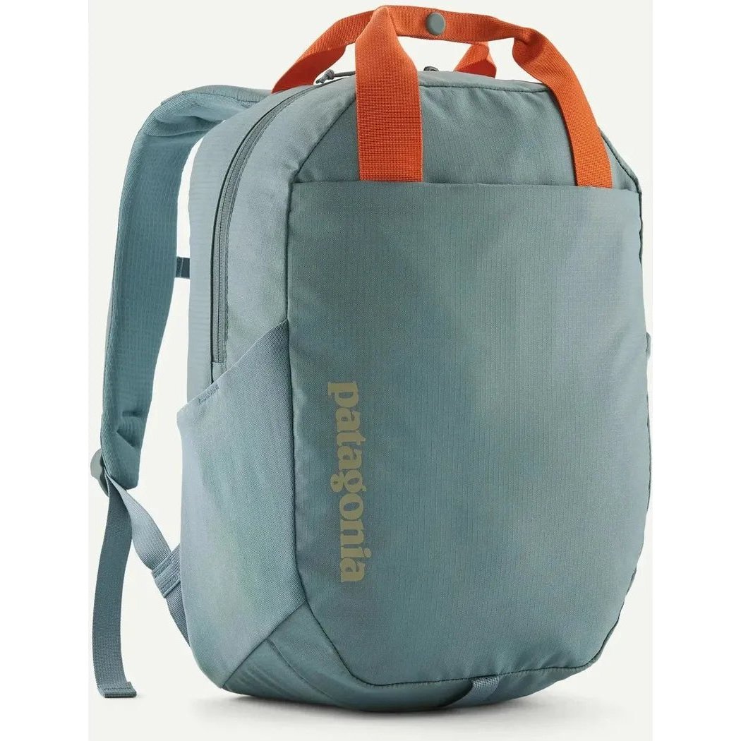 Side view of the Patagonia Atom Tote Pack 20L in Blue Sage showing the front pocket and orange top handles against a white background.