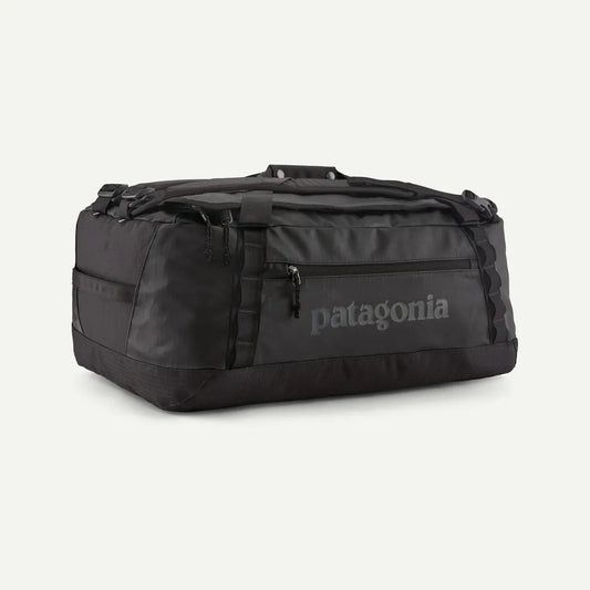 A front view of the Patagonia Black Hole Duffel 55L in Black w/Black with a zippered pocket and Patagonia logo on a white background.