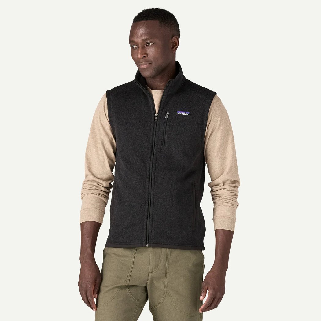A front view of the Patagonia Men's Better Sweater Vest in Black on a model wearing khaki pants against a white background.