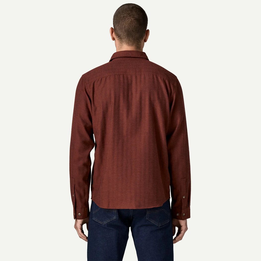 Back view of the Patagonia Men's Long Sleeve Cotton in Conversion LW Fjord Flannel Shirt in Mirror Weave Rusty Red on a model against a white background.
