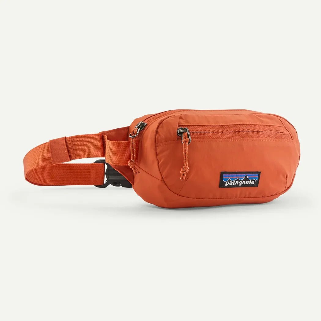 Side view of the Patagonia Terravia Mini Hip Pack in Aqua Stone showing the zippered pocket and adjustable strap against a white background.