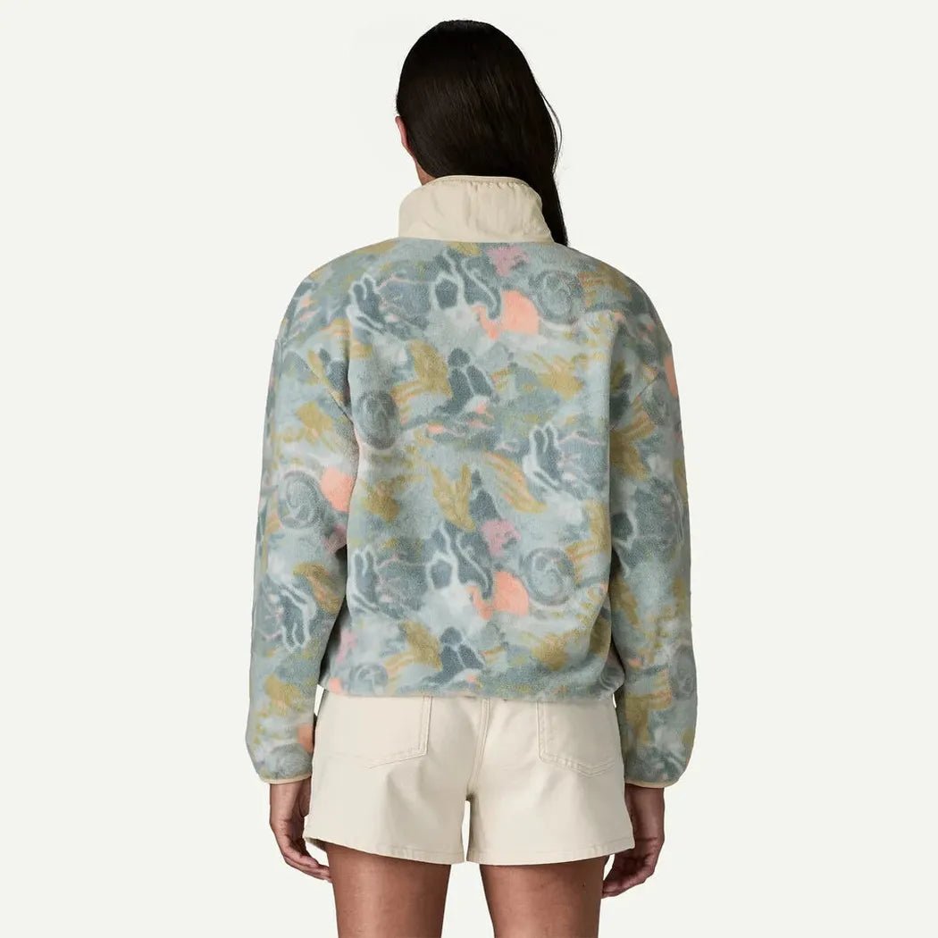Back view of the Patagonia Women's Synch Marsupial in Moon Tripper: Virtually Blue on a model wearing cream shorts against a white background.