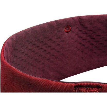 The Petzl Adjama dark red climbing harness close-up shows the padded interior and stitching against a white background.