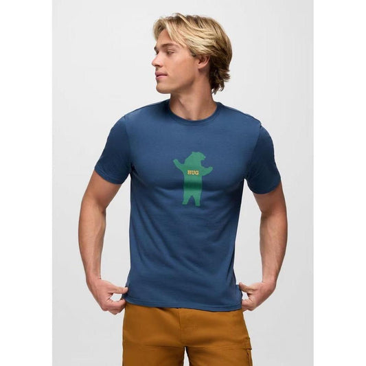 A side view of the Prana Men's Bear Squeeze Journeyman SS Tee in Bluff Blue on a model against a white background.