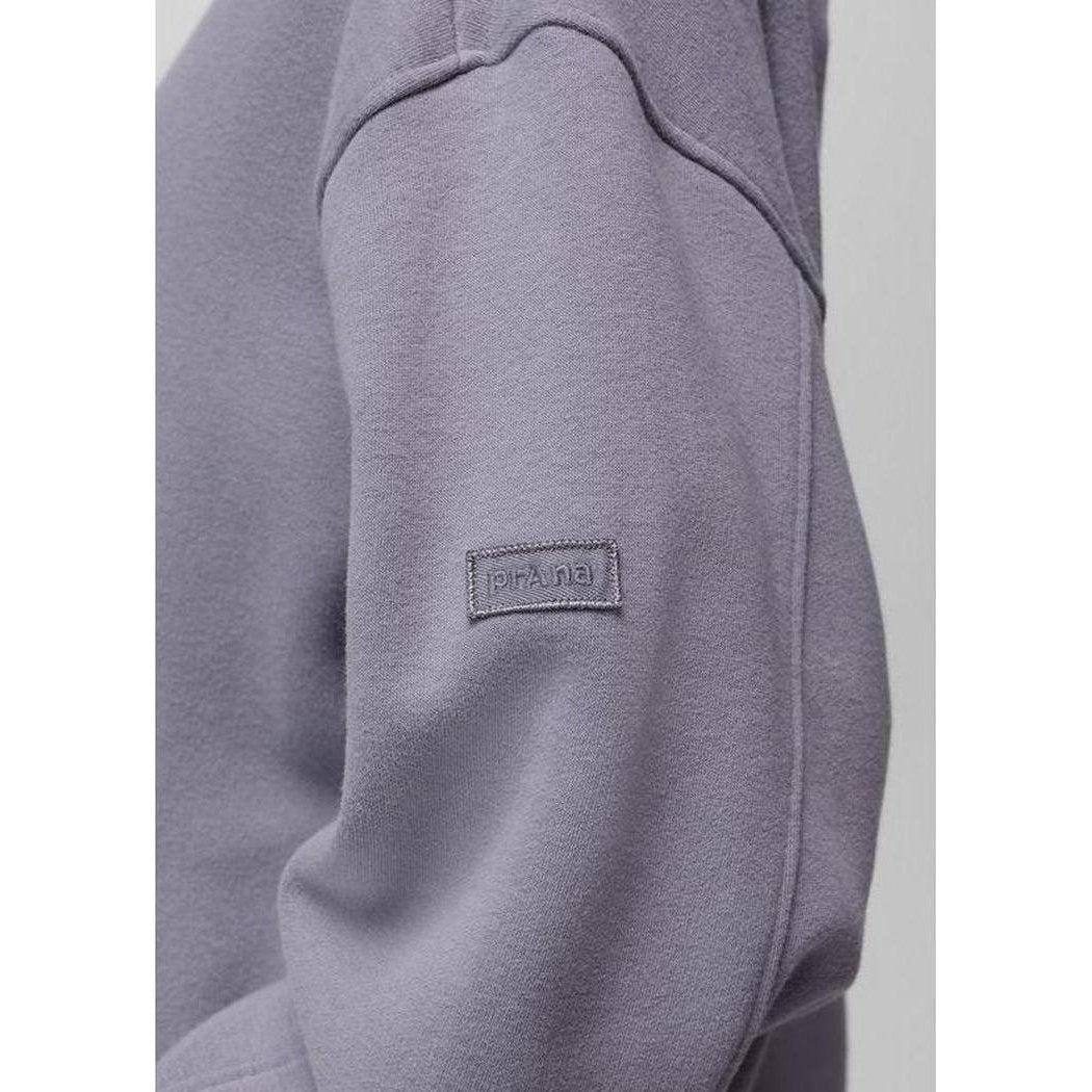 A close-up of the Prana Sample - Women's DreamFleece Hoodie in Taro showing the brand tag on the sleeve against a plain background.