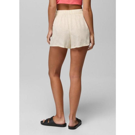 Back view of the Prana Sample - Women's The Bahamas Short in BeachPebbleShor on a model wearing black sandals against a gray background.
