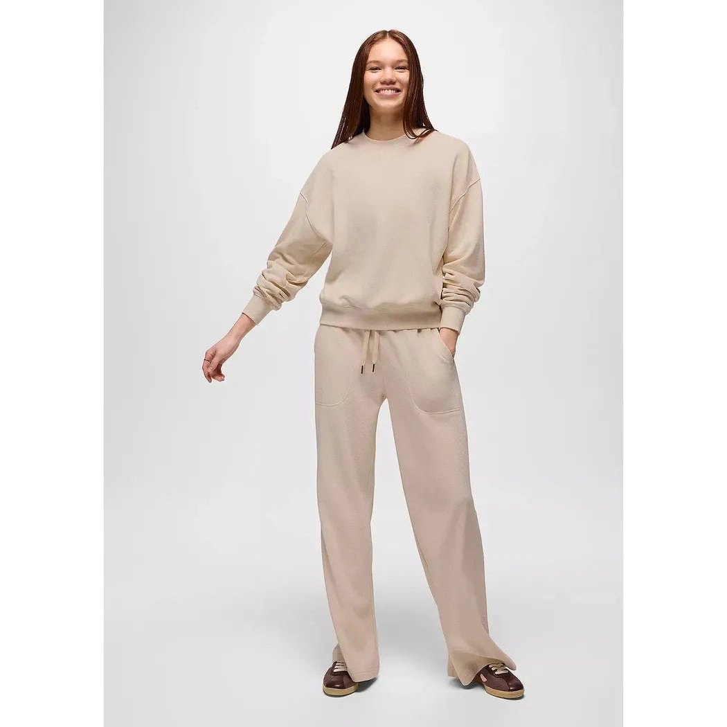 A woman wearing the Prana Women's Cozy Up Crew Sweatshirt in Canvas Heather stands against a plain white background.