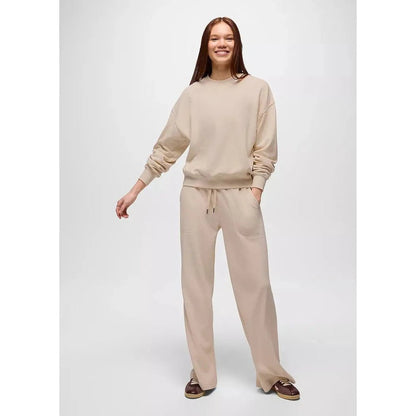A woman wearing the Prana Women's Cozy Up Crew Sweatshirt in Canvas Heather stands against a plain white background.