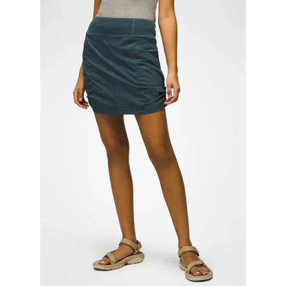 A front view of the Prana Women's Keon Skort in Grape Leaf on a model wearing tan sandals against a white background.