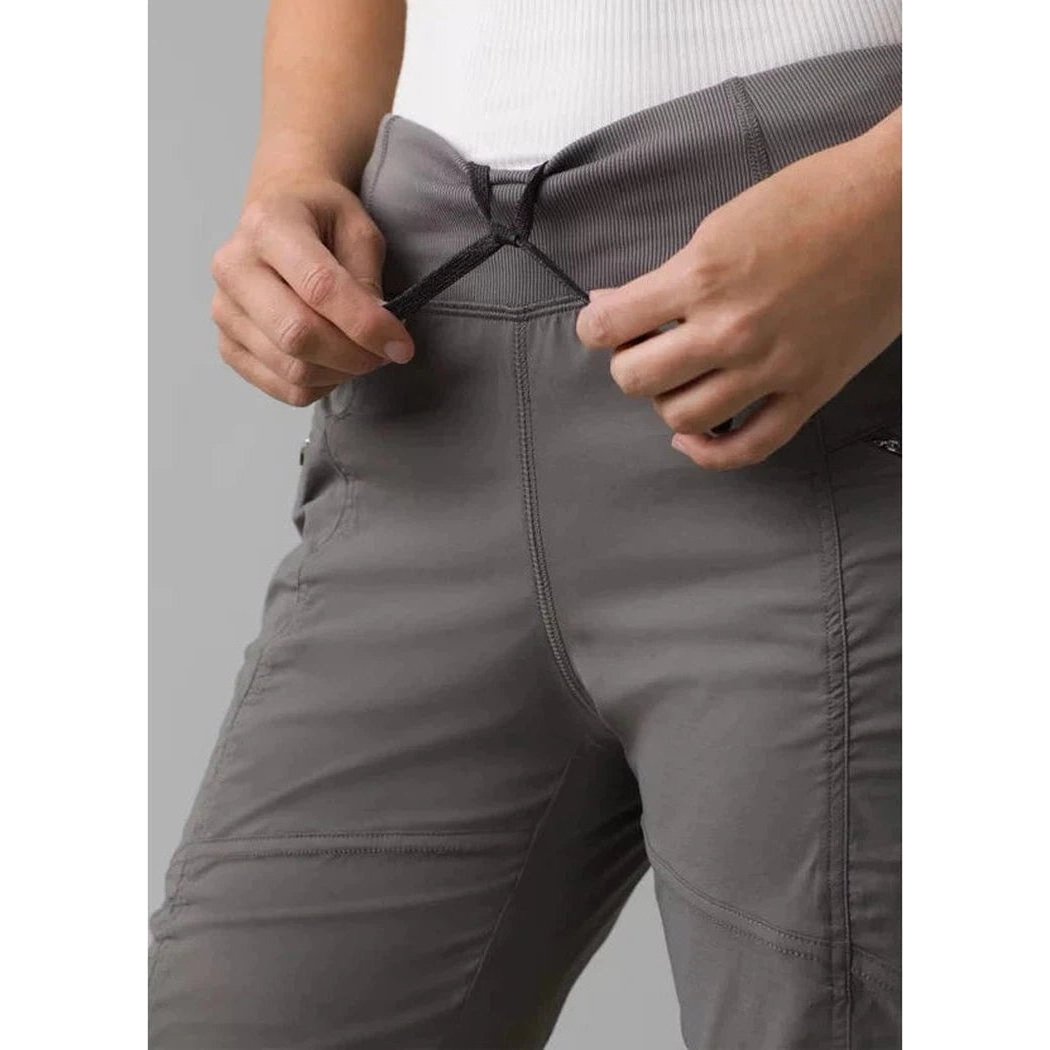 A close-up of a woman wearing the Prana Women's Koen Pant in Black, showing the waistband and zipper detail against a plain background.