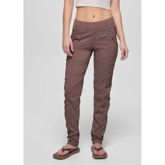 A front view of the Prana Women's Koen Pant in Black on a model wearing brown flip flops against a plain background.