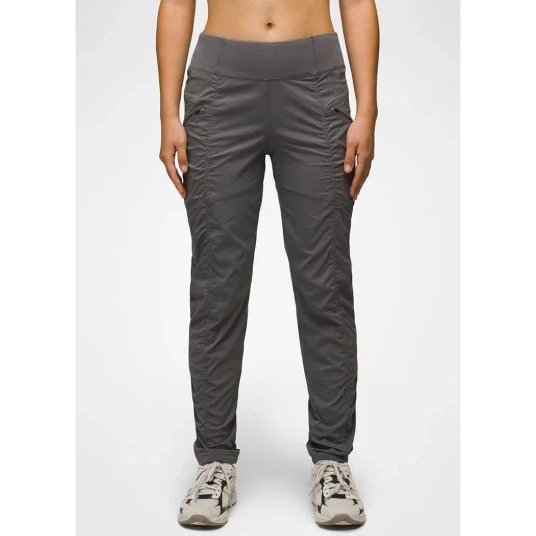 A front view of the Prana Women's Koen Pant in Black, showing the high waist and cargo pockets on a model wearing white sneakers against a plain background.