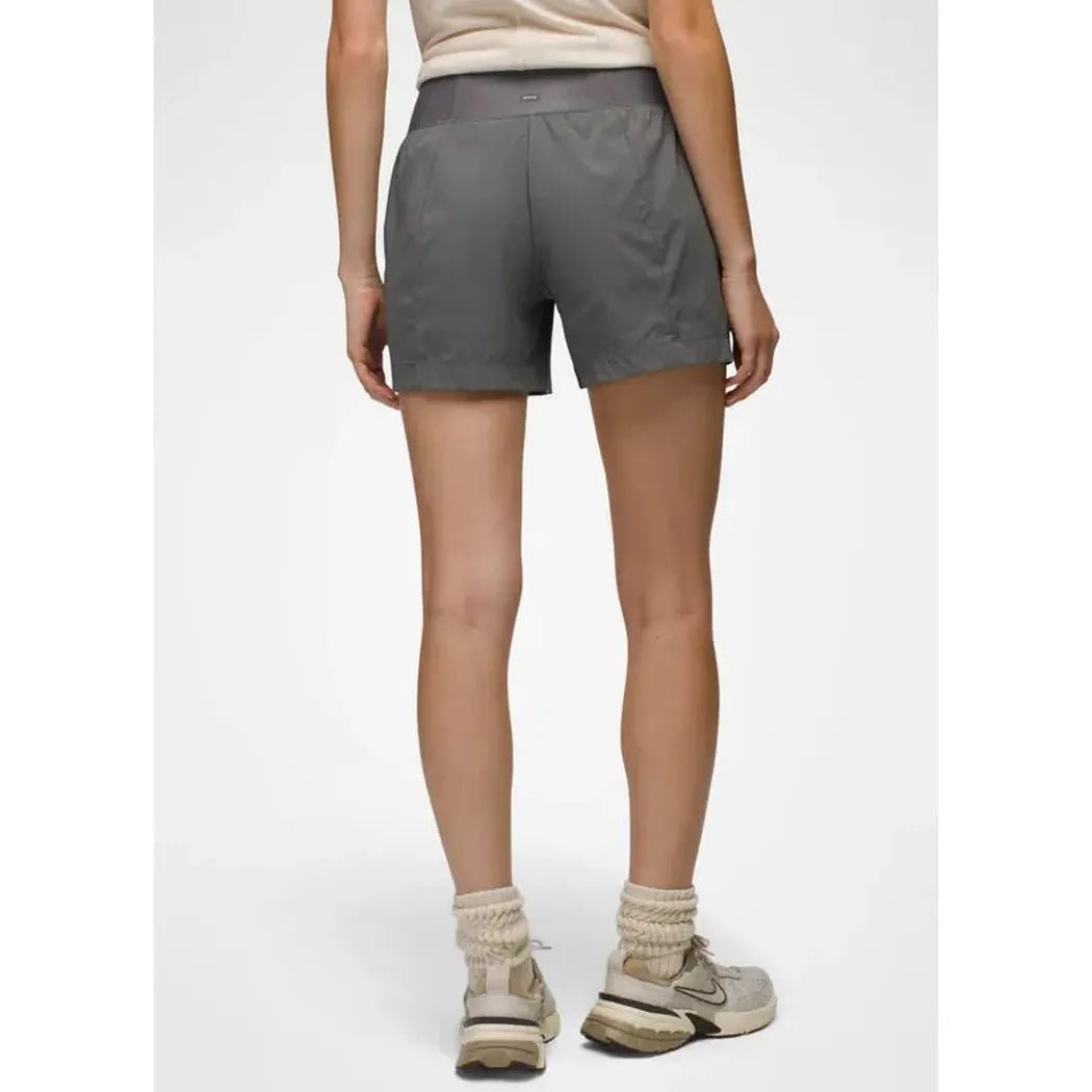 Back view of the Prana Women's Koen Short in Grape Leaf on a model wearing light-colored sneakers against a plain white background.