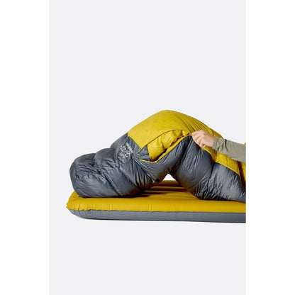 Side view of the Rab Neutrino 0C / 32F sleeping bag in Graphene/Dark Pollen on a yellow mat against a white background.