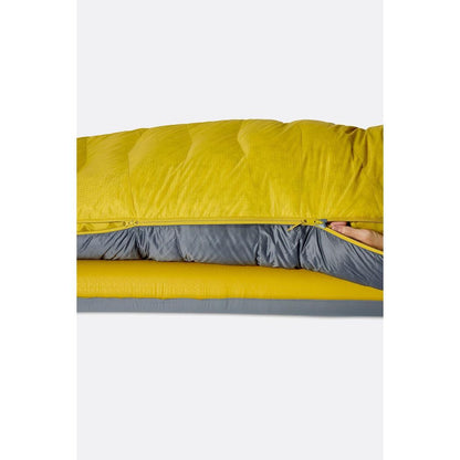 A side view of the Rab Neutrino 0C / 32F Graphene/Dark Pollen sleeping bag showing the zipper and a hand reaching in against a white background.