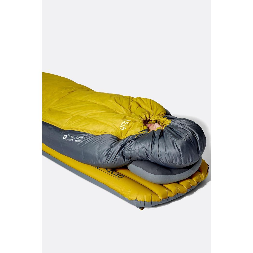 Side view of the Rab Neutrino 0C / 32F sleeping bag in Graphene/Dark Pollen on a yellow air mattress with a gray pillow.